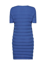 The SPRING PLEATS dress by ISSEY MIYAKE is a royal blue, short-sleeved, knee-length piece with a fitted silhouette and vertical ribbed pattern in high-twist polyester, shown on a plain white background.