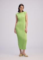 A woman wears ISSEY MIYAKE's LINEN LIKE RIB PLEATS—a fitted, sleeveless light green ankle-length dress—paired with matching sandals. She has straight dark hair and a neutral expression against a plain light background.