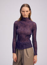 A person with straight, shoulder-length hair wears the ISSEY MIYAKE CHIFFON TWIST 2, a sheer textured purple pleated top made from recycled polyester, paired with high-waisted beige pants against a plain light background.