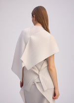 A person with straight brown hair faces away, wearing ISSEY MIYAKE’s PLEATED ON PLEATS: a high-neck, structured white outfit featuring layered pleats and angular back details against a plain light background.
