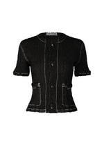 The ISSEY MIYAKE WAVELET ENSEMBLE is a black textured short-sleeved cardigan-style button-up shirt with white contrast stitching, two front pockets, and a scalloped hem. Made from lightweight polyester, it features the brand label inside the collar. - BLACK (no.15)