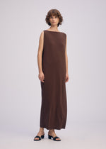 A person with short curly hair wears the DRAPE JERSEY-66 sleeveless dress by ISSEY MIYAKE and black open-toe heeled sandals, standing against a plain light background.