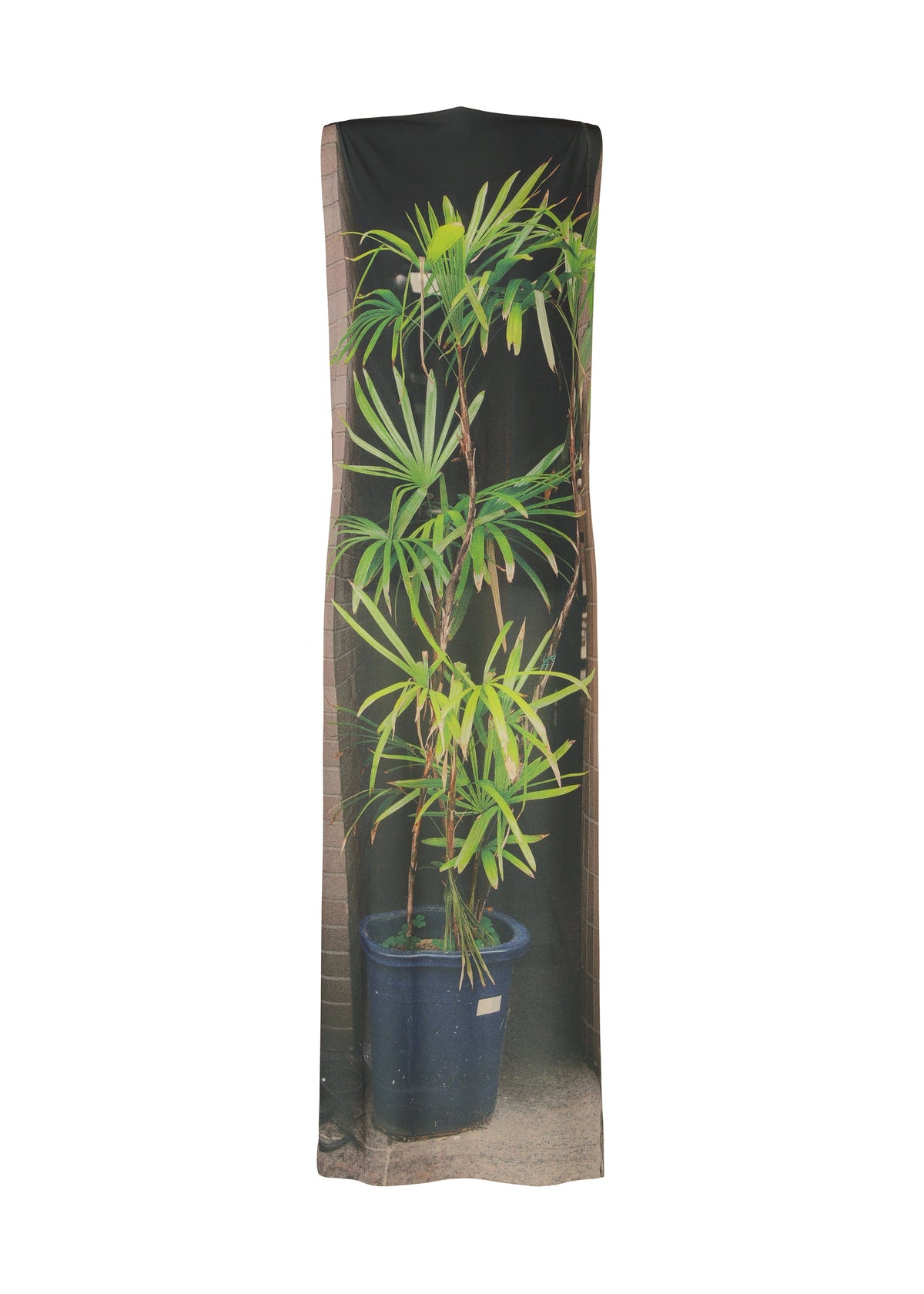 The ISSEY MIYAKE URBAN JUNGLE JERSEY is a long, sleeveless dress in soft jersey, featuring a potted plant with slender leaves set against brown bricks, evoking realistic jungle greenery. view 1 of 6