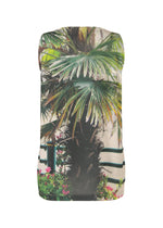 The ISSEY MIYAKE URBAN JUNGLE JERSEY is a sleeveless top made from soft jersey, showcasing a vibrant jungle print with palm trees, green leaves, and flowers on black-and-white stripes.