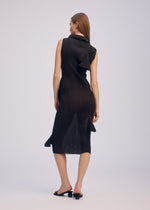 A woman with straight, light brown hair faces away, showcasing the ISSEY MIYAKE ADVENTITIOUS: HIGH-NECKS sleeveless knit dress with sculptural wavy details, paired with black open-toe heels against a plain light gray background.