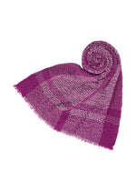 The BUMPY WOOL STOLE by ISSEY MIYAKE, shown in purple and pink with fringed edges, is styled with one end neatly rolled and the rest draped in a triangular form on a white background, highlighting its distinctive bumpy texture that enhances the stole’s elegant visual depth. - PURPLE-HUED （no.86）