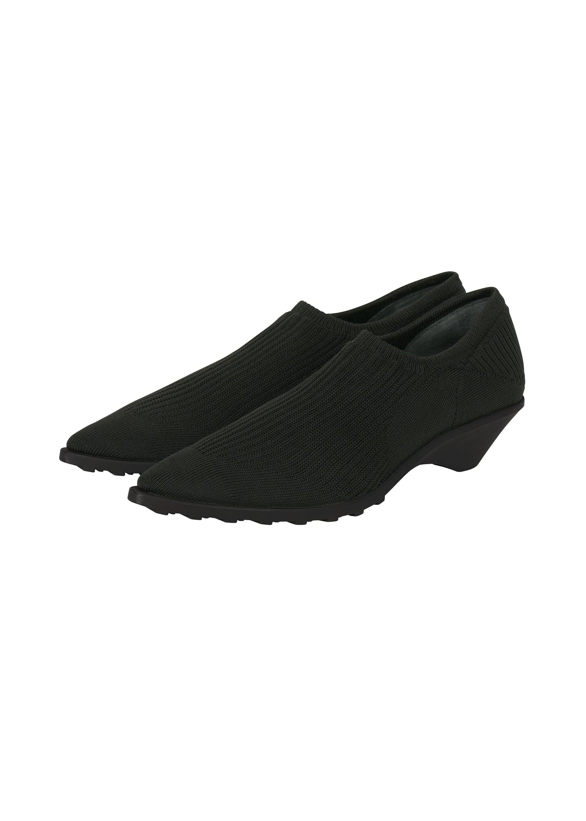 A pair of black, slip-on, pointy-toe shoes with a low wedge heel and textured sole, designed in the signature ISSEY MIYAKE ANNA style, placed on a white background. view 9 of 9