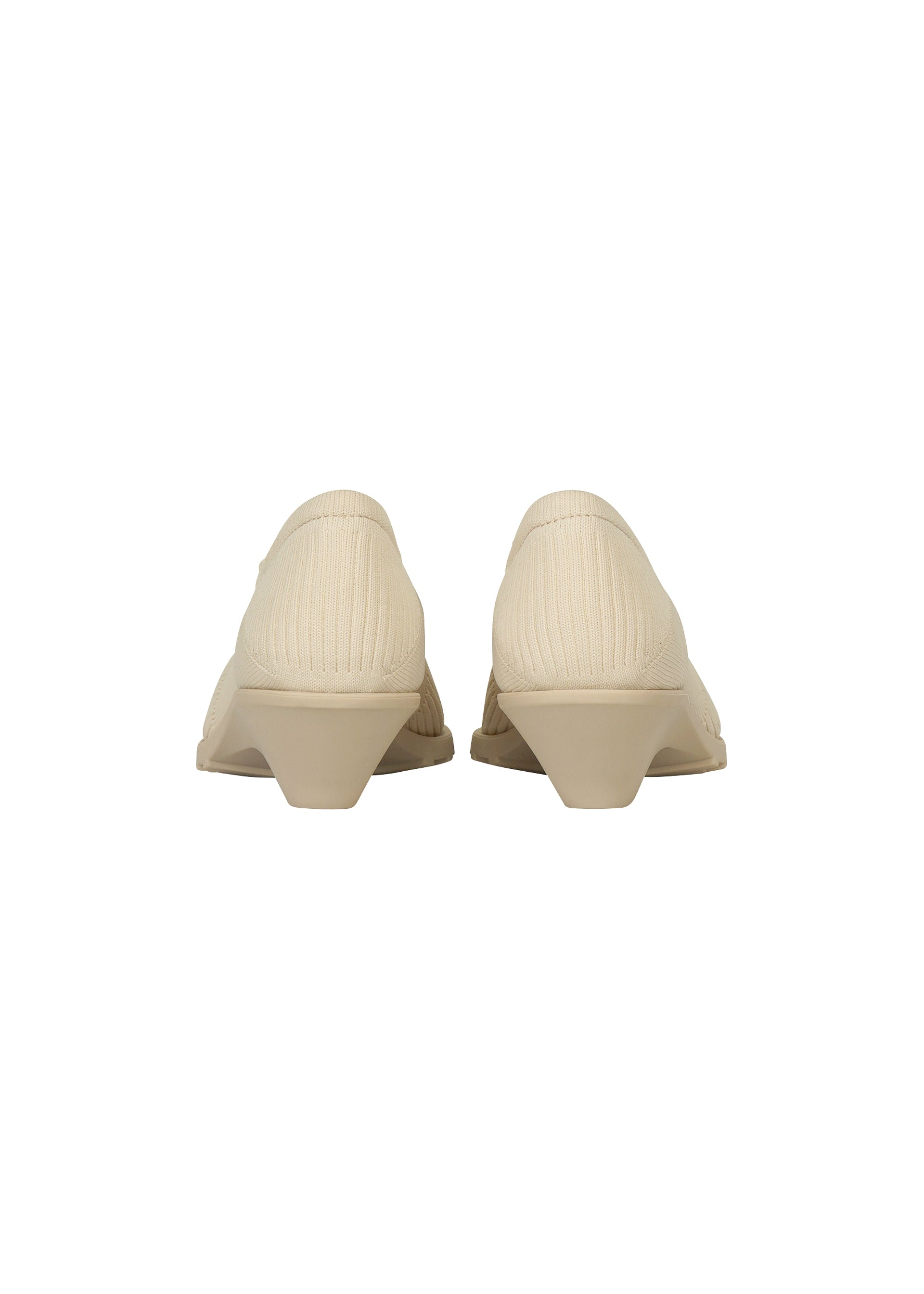 Zoomed view Back view of a pair of beige, low-heeled, closed-toe ISSEY MIYAKE ANNA shoes with a textured fabric upper reminiscent of knitted footwear, set against a plain white background.