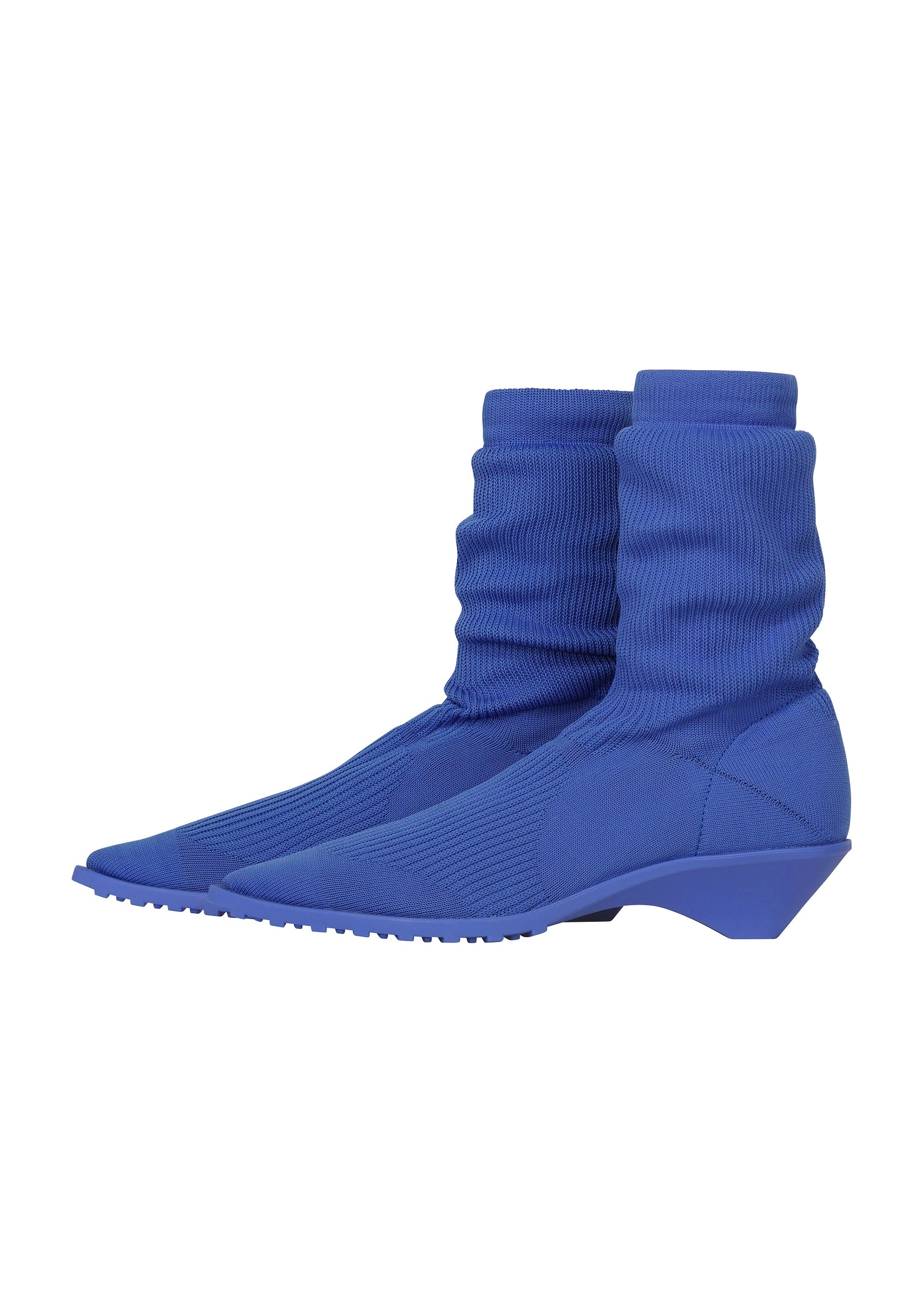 Zoomed view A pair of blue sock boots with pointed toes, ribbed fabric, and low angled heels, shown against a white background—these ISSEY MIYAKE ANNA shoes offer a stylish take on knitted footwear.