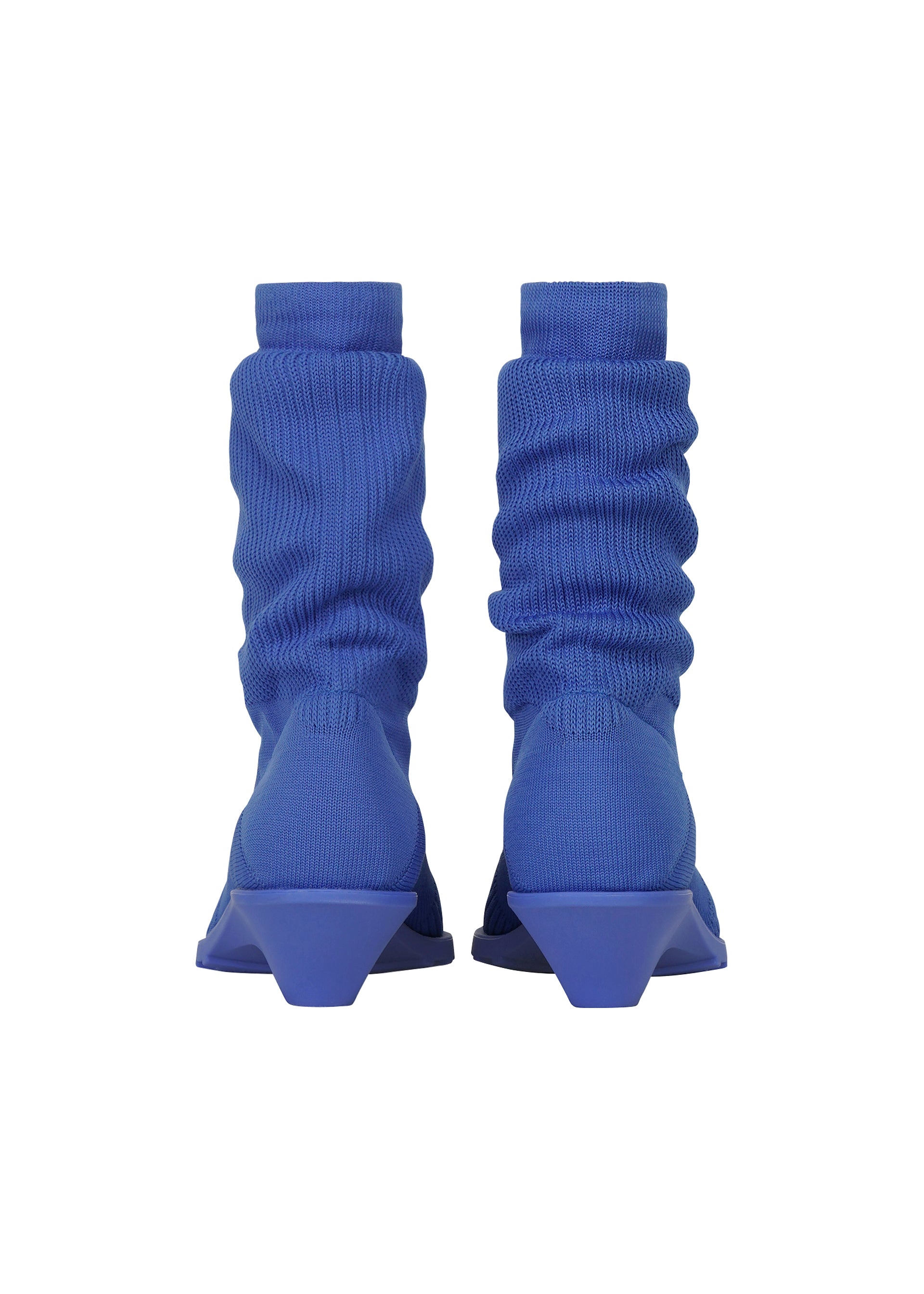 Zoomed view A pair of ISSEY MIYAKE ANNA blue ribbed sock-like boots with geometric, angular heels—reminiscent of knitted footwear—shown from the back against a white background.