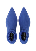 Top view of a pair of pointed-toe, ribbed, royal blue sock boots showcasing a sleek, sock-like shoe design with ISSEY MIYAKE and ANNA text visible on the black inner soles.