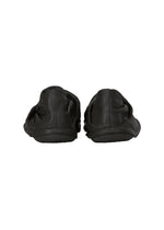 A pair of black PEU FORM slip-on shoes from ISSEY MIYAKE, featuring a wrinkled design and shown from the back against a white background.