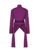 Introducing the CALLIGRAPH jacket from ISSEY MIYAKE—a luxurious deep purple, long-sleeve wool piece featuring a high collar and two wide fabric panels that cross elegantly at the lower back, flowing into long decorative sashes. Inspired by the ISSEY MIYAKE Autumn Winter Collection, this jacket showcases a woven nashiji pebbled texture for added sophistication and visual interest.