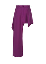 The CALLIGRAPH pants by ISSEY MIYAKE are crafted from premium purple wool and showcase an asymmetric design, featuring one straight leg and a draped, skirt-like overlay on the other. With a front zipper and belt loops at the waistband, these pants reflect the brand’s signature innovative style.