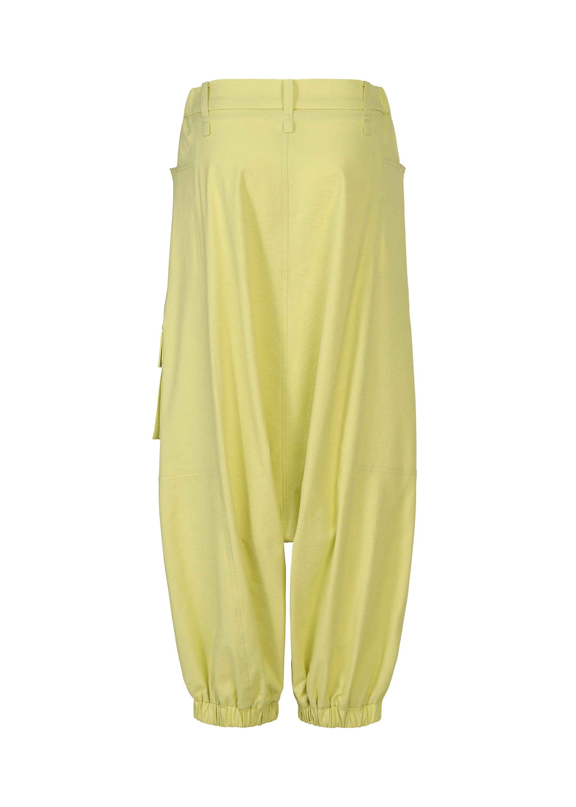 Zoomed view The ISSEY MIYAKE GRAINY PANTS are yellow baggy sarouel trousers made from stretch cotton, featuring an elasticated hem, belt loops, and side pockets, shown against a white background.