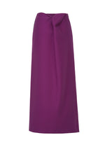 The CALLIGRAPH skirt by ISSEY MIYAKE is a long, high-waisted piece in purple, crafted from luxurious worsted wool with a minimalist design and a subtle knot detail near the waistband, shown against a white background.