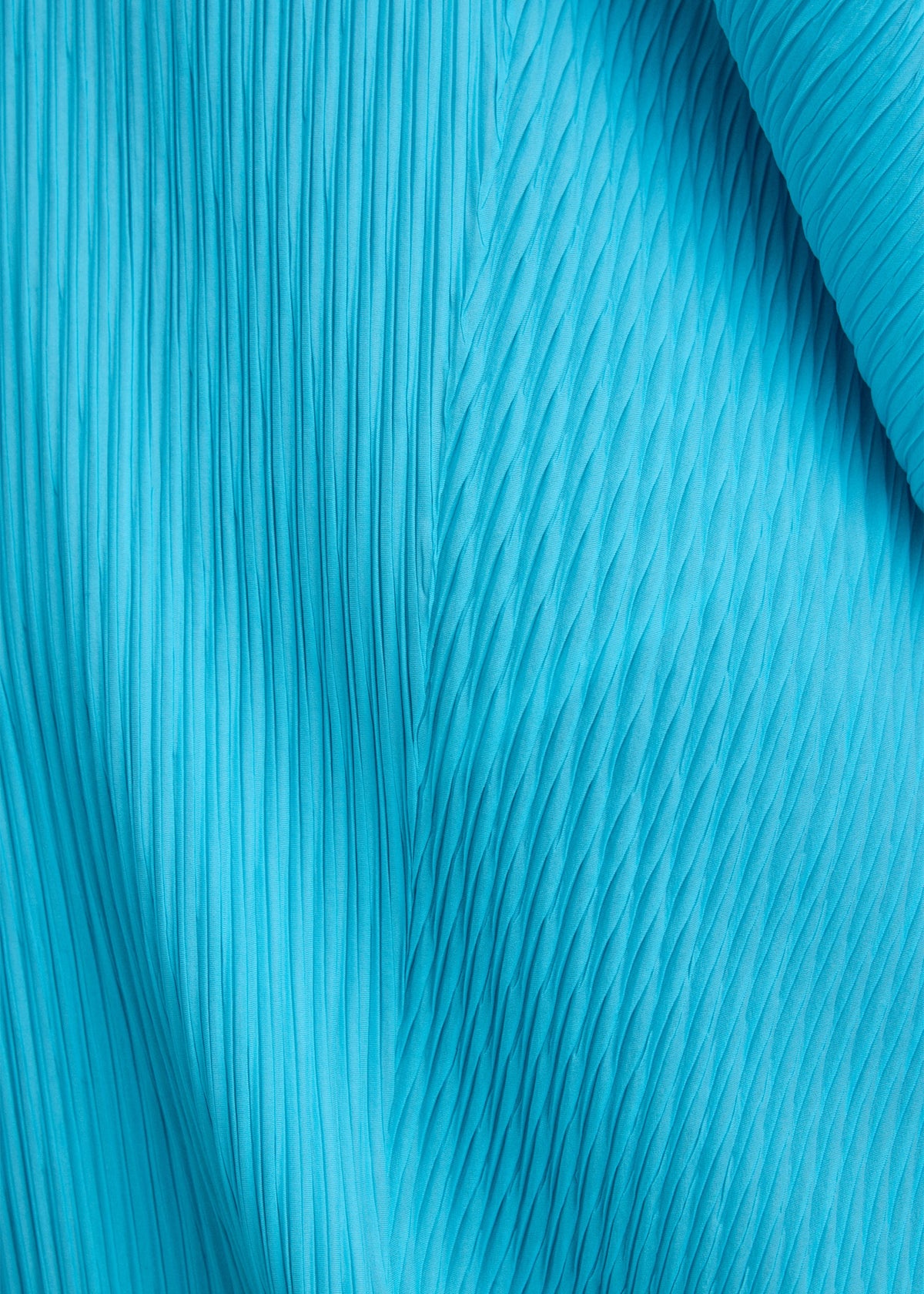 Close-up of LEAF PLEATS by ISSEY MIYAKE, featuring bright blue fabric with double pleating and textured patterns that run vertically and diagonally, evoking a dynamic visual effect reminiscent of a leaf silhouette. view 7 of 7