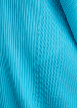 Close-up of LEAF PLEATS by ISSEY MIYAKE, featuring bright blue fabric with double pleating and textured patterns that run vertically and diagonally, evoking a dynamic visual effect reminiscent of a leaf silhouette.
