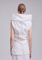 A person with brown hair tied back is shown from behind wearing the ALLOW top by ISSEY MIYAKE, featuring white washi paper-blend fabric, a high collar, and a long vertical back zipper against a light gray background.