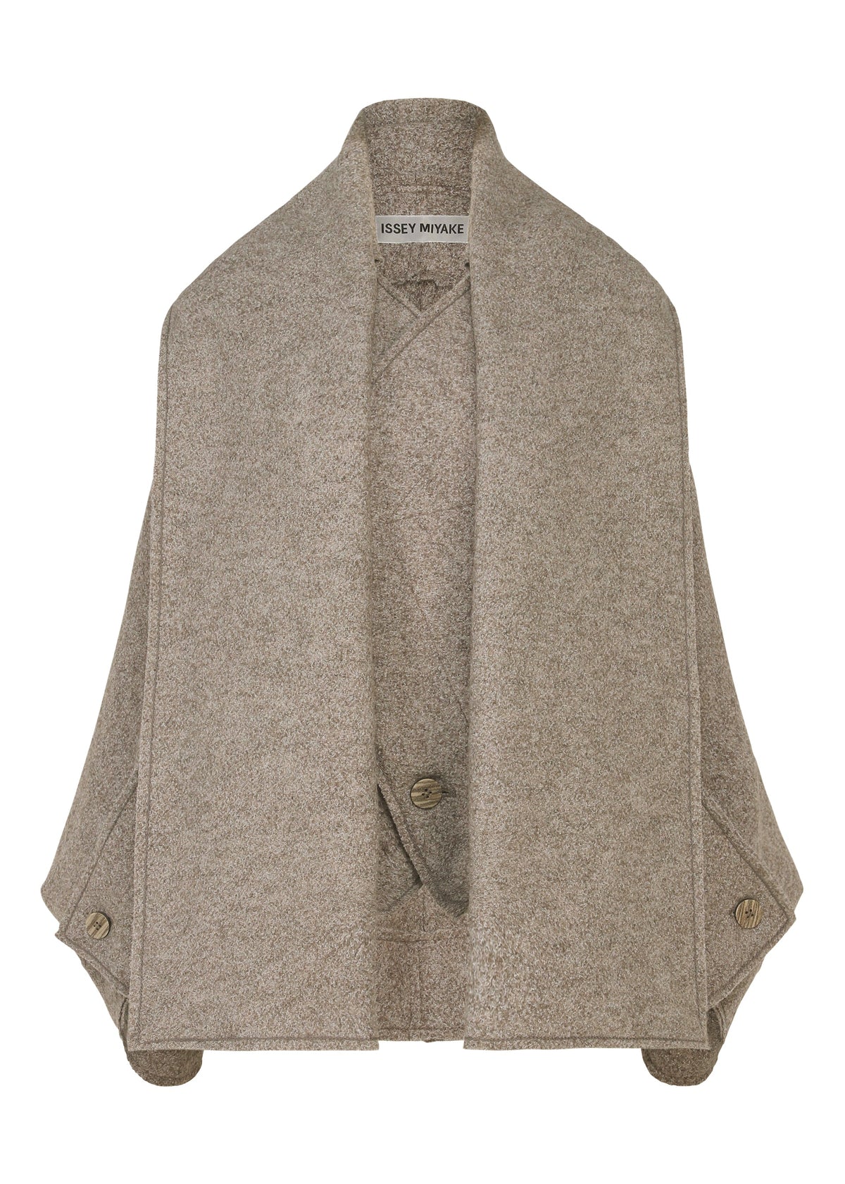 The WOOLEN GRANITE by ISSEY MIYAKE is a light brown merino wool cape featuring wide lapels, side button details, and a soft, textured fabric with the brand label at the neck. view 2 of 7