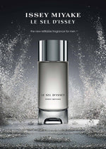 A 150mL bottle of ISSEY MIYAKE PARFUMS LE SEL EAU DE TOILETTE for men stands upright, featuring sleek silver accents and enveloped by dynamic sprays of water. Text above introduces it as a new refillable salt eau de toilette.
