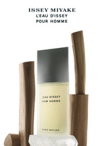 A bottle of ISSEY MIYAKE PARFUMS L'EAU D'ISSEY POUR HOMME EAU DE TOILETTE 200mL stands amid upright wooden pieces and ice, with the brand and product name shown above in black text on a white background.