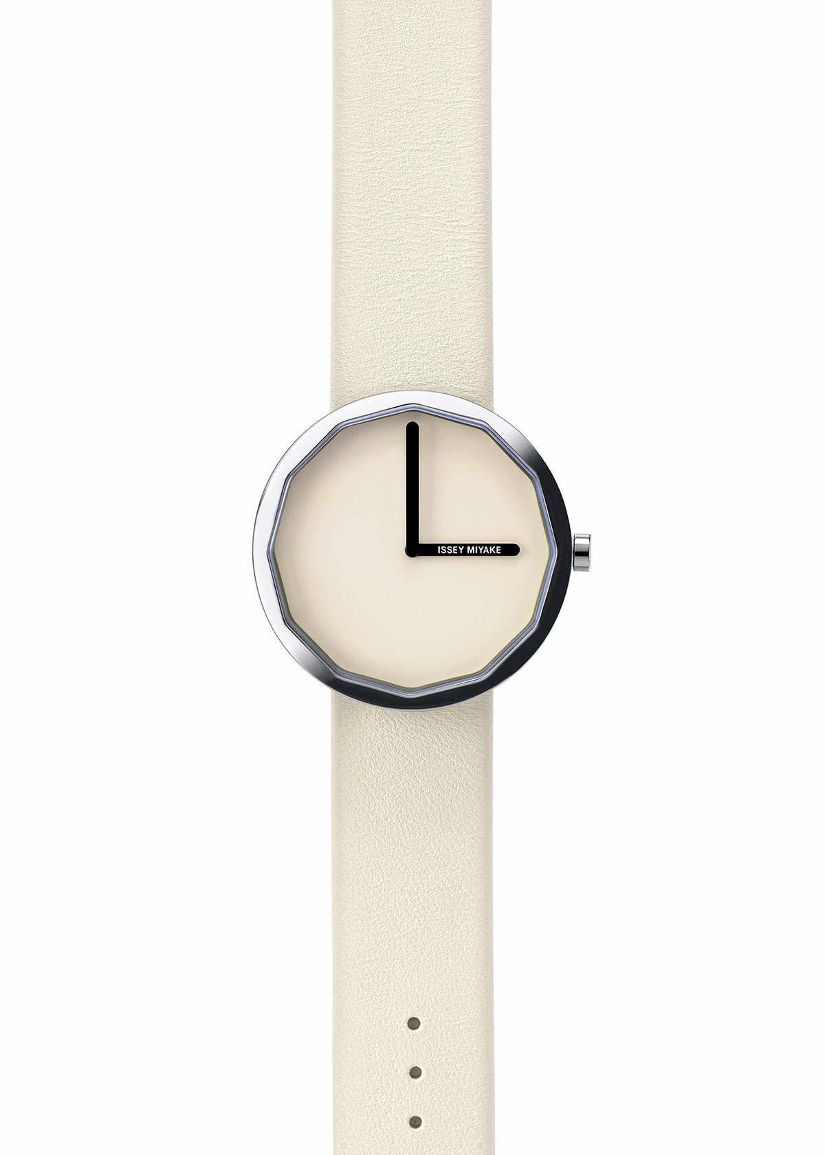 Zoomed view The ISSEY MIYAKE WATCH TWELVE, designed by Naoto Fukasawa, features a cream strap and face, a silver octagonal bezel, simple black hands, and no numbers. ISSEY MIYAKE is at the 3 o'clock position on the minimalist dial.