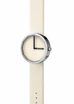The ISSEY MIYAKE WATCH TWELVE, designed by Naoto Fukasawa, is a minimalist wristwatch with a cream strap and dial, faceted round silver bezel, black hands, and the brand name displayed on the face.