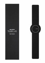 A minimalist black ISSEY MIYAKE WATCH from the TWELVE collection, designed by Naoto Fukasawa, with a numberless round face, sits beside its rectangular black box labeled ISSEY MIYAKE WATCH TWELVE Designed by Naoto Fukasawa.