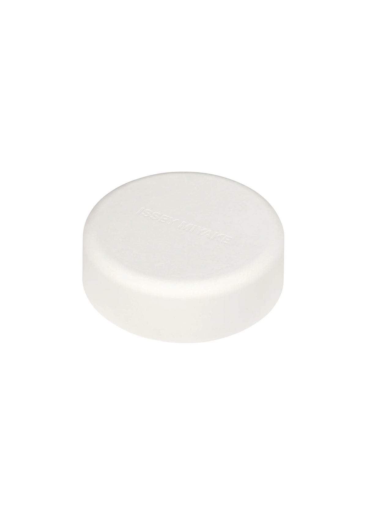 A single round, white tablet with a smooth surface and subtle, indented text rests on a plain white background—its minimalist aesthetic reflecting the refined design sensibility of Tokujin Yoshioka, as seen in the O watch for ISSEY MIYAKE WATCH. view 4 of 6
