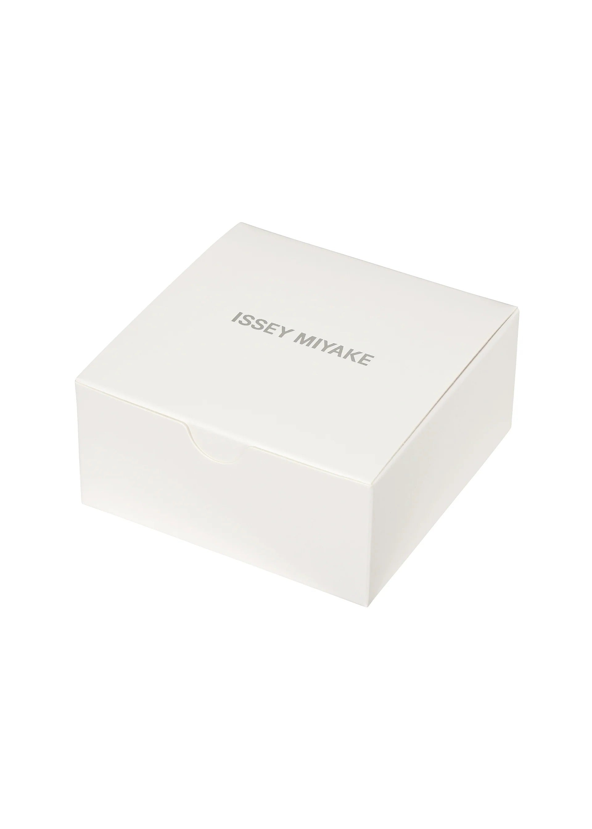 Zoomed view A plain white square box with ISSEY MIYAKE WATCH printed in gray uppercase letters on the lid. Designed with a simple, minimalist aesthetic and set against a white background, the box perfectly embodies the iconic style of Tokujin Yoshioka—the designer behind “O” by ISSEY MIYAKE WATCH, as well as the brand’s renowned lightweight bangle watch and transparent watch collections.