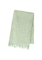 The SHRINK BORDER STOLE by IM MEN is a light green, breathable, high-twist cotton stole with a waffle pattern and fringed edges, shown neatly folded on a white background. - SAGE GREEN （no.66）