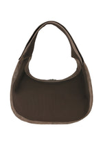 The IM MEN CARVED LEATHER BAG is a brown, crescent-shaped textured leather bag with a wide strap and ceramic-inspired design, shown against a white background.