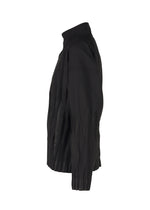 A side view of the IM MEN WAFT BLACK jacket, featuring wrinkle-resistant fabric, a high collar, and pleated details at the sides and hem, set against a plain white background.