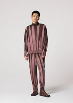 A person stands against a plain light background wearing the IM MEN EDGE matching set—loose, long-sleeved top and pants with vertical maroon and brown abstract stripes—paired with brown shoes.