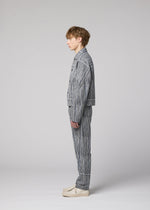 A person with short light brown hair stands in profile against a light gray background, wearing the IM MEN CURVINESS cotton-linen textured jacket and matching striped pants set, paired with light-colored shoes.