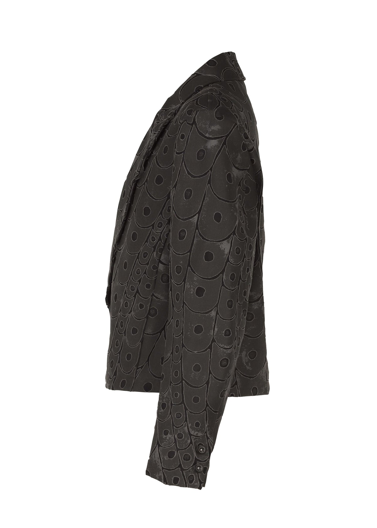 The UROKOMON short jacket by IM MEN features a black, textured scale-like design inspired by Shoji Kamoda, with a circular discs-and-rings pattern, shown from the side against a white background. view 4 of 8