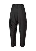IM MEN’s SWING BLACK pants are black, loose-fit harem pants with an elastic waistband and dropped crotch. Made from wrinkle-resistant fabric, they feature a relaxed drape and cropped legs, shown here against a white background.