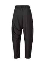 The IM MEN SWING BLACK harem pants feature a loose silhouette, elastic waistband, and are made from wrinkle-resistant fabric, shown against a white background.
