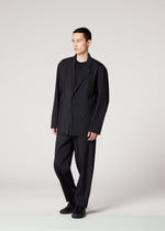 A person stands against a plain background wearing the IM MEN AIR PLEATS BLACK suit, paired with a matching shirt and shoes, looking slightly to the side with a neutral expression.