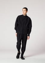A person stands against a plain white background, wearing the IM MEN WAFT BLACK loose-fitting button-up shirt with pleats and wrinkle-resistant pants with gathered ankles, paired with black shoes. They look slightly to the side.