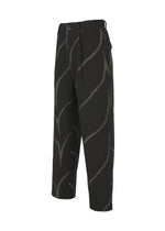 The EARTH pants by IM MEN are black, cropped, and loose-fitting with a bold jagged light gray wave pattern, belt loops, and a pleated front, shown on a plain white background.