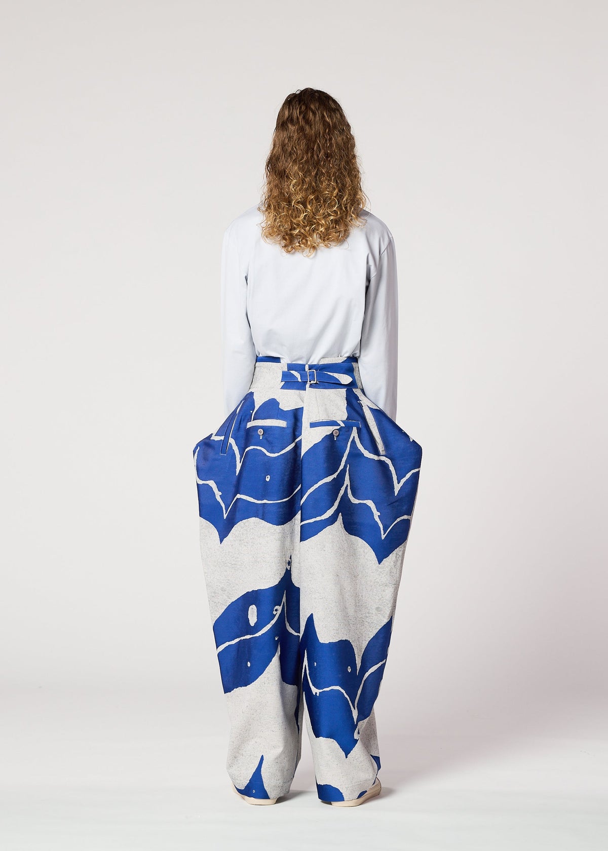 A woman in a long skirt stands gracefully, her style echoing the elegance of IM MEN’s INLAY ceramic-inspired pants. view 5 of 6