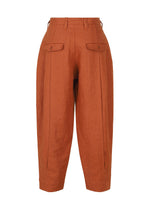 The IM MEN TOUGH LINEN burnt orange high-waisted pants feature front pleats, buttoned flap pockets, belt loops, and a tapered leg in durable linen with natural texture, shown on a plain white background.