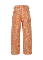 The IM MEN UROKOMON pants feature a high-waist, wide-leg silhouette in orange with abstract cream circle designs, plus visible belt loops and back pockets.