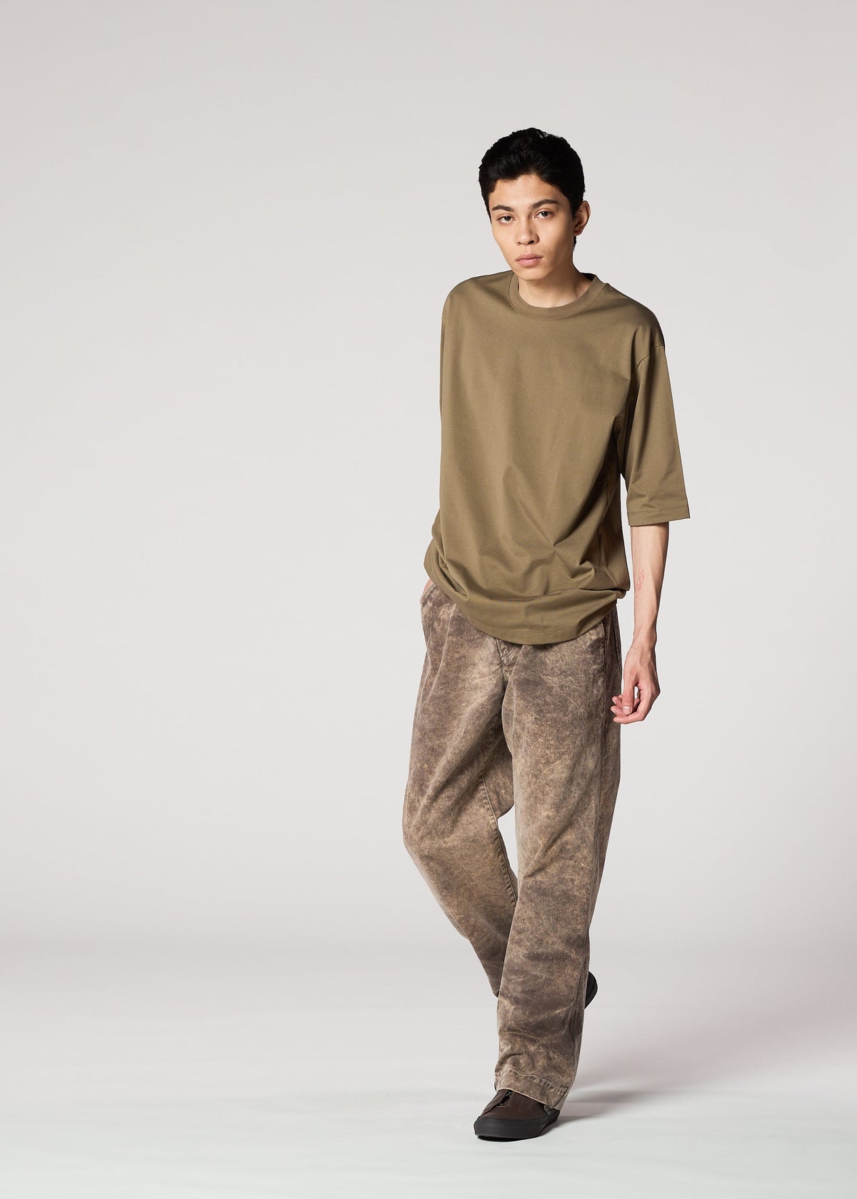 A person with short dark hair wears IM MEN's ELEMENTS: a loose olive t-shirt and wide-legged, faded brown cotton pants, standing against a plain light background. view 8 of 8