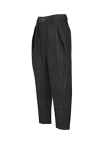The CURVINESS trousers by IM MEN are dark gray, pinstriped, and cropped with pleats, angled side pockets, and a button closure. Made from cotton-linen blend for a relaxed loose fit, they're shown on a white background.