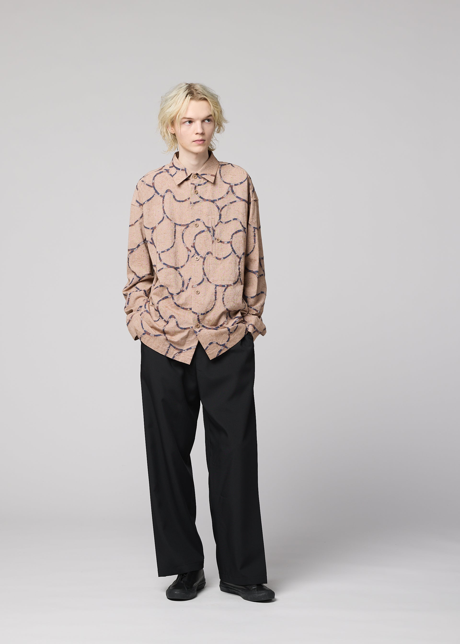 Zoomed view A person with short, blonde hair stands against a plain background, wearing IM MEN's VASE JACQUARD SHIRT, black wide-leg trousers, and black shoes, with hands in their pockets.