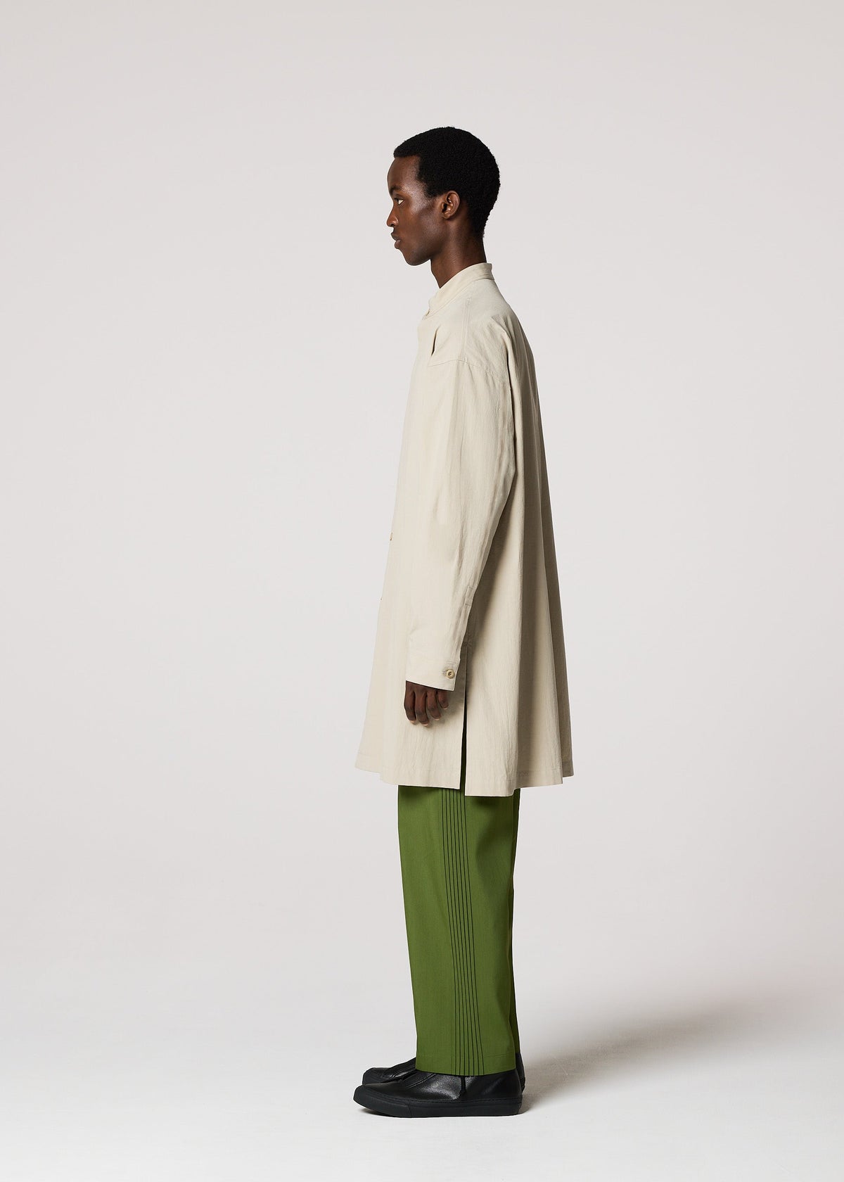 A person stands in profile wearing the IM MEN WHITE SHIRT with green pleated pants and black shoes against a plain light background—an understated look ideal for formal occasions. view 6 of 8