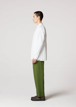 A person in profile against a plain background wears the IM MEN WRINKLE SHIRT with long sleeves, paired with olive green pants and dark shoes.